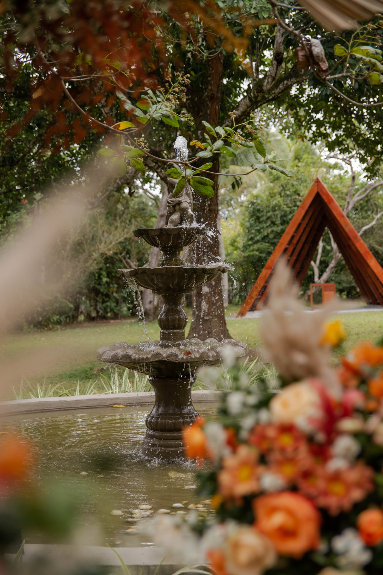 Fonte de água do jardim com o altar triangular de madeira ao fundo